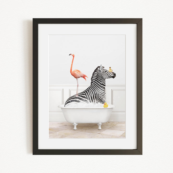 A framed image depicting a zebra sitting in a bathtub, with a flamingo standing on its back and a yellow rubber duck floating on the water.
