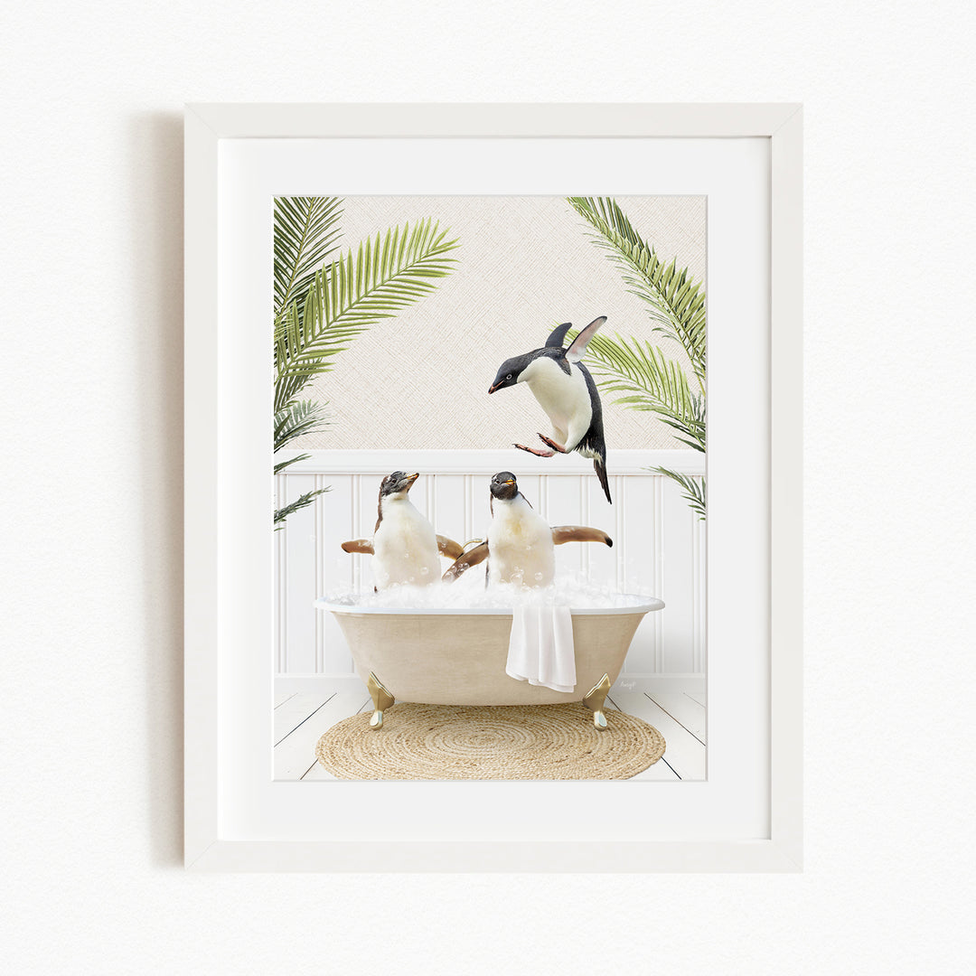 A framed image depicting three penguins sitting in a bathtub, surrounded by palm leaves.