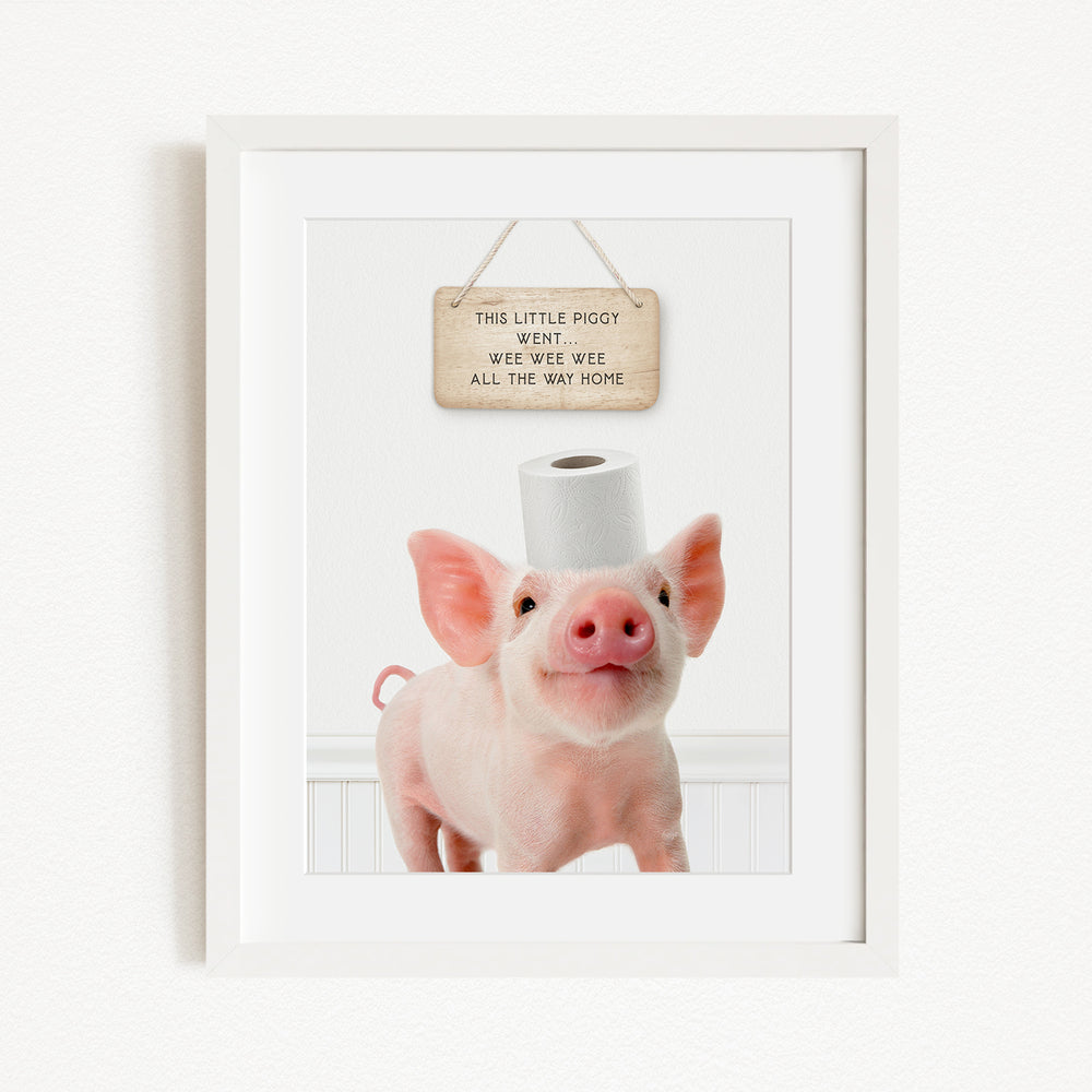 A framed image of a pig with a sign above it that reads "This little pig went weee weee weee all the way home".
