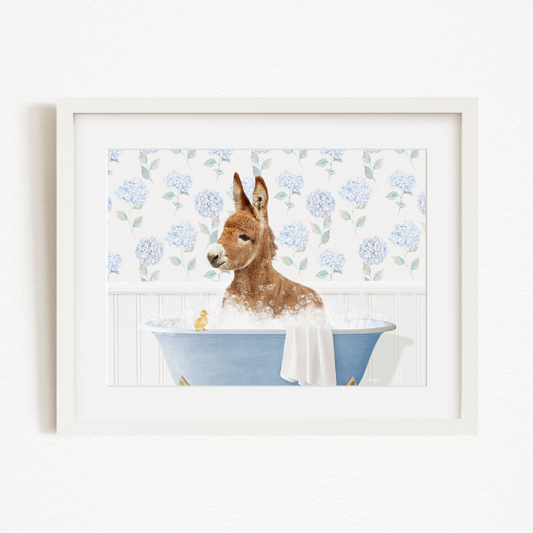 A brown donkey is sitting in a blue bathtub filled with water, surrounded by a floral pattern on the wall behind it.