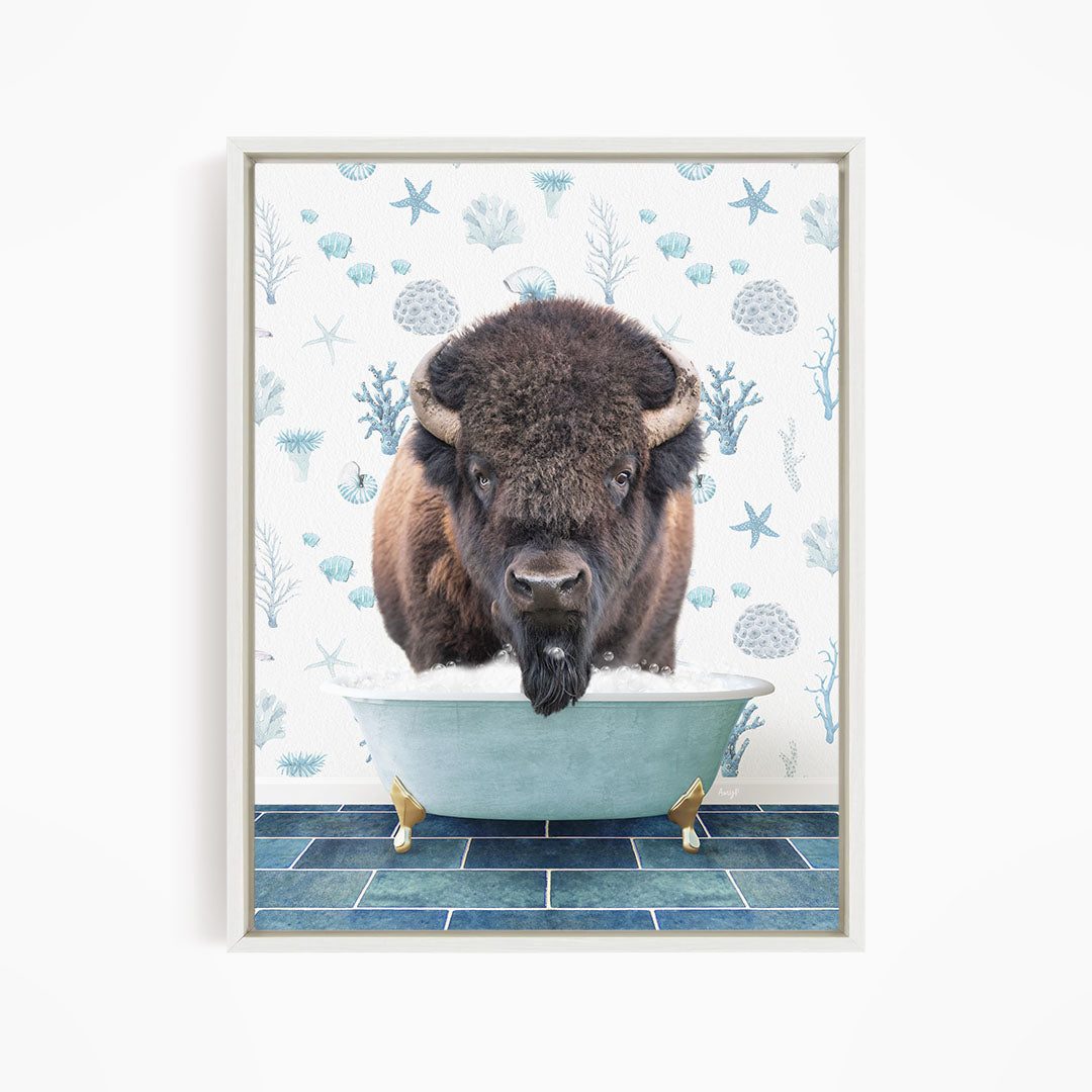 A buffalo is sitting in a bathtub filled with water, surrounded by blue and white floral patterns.