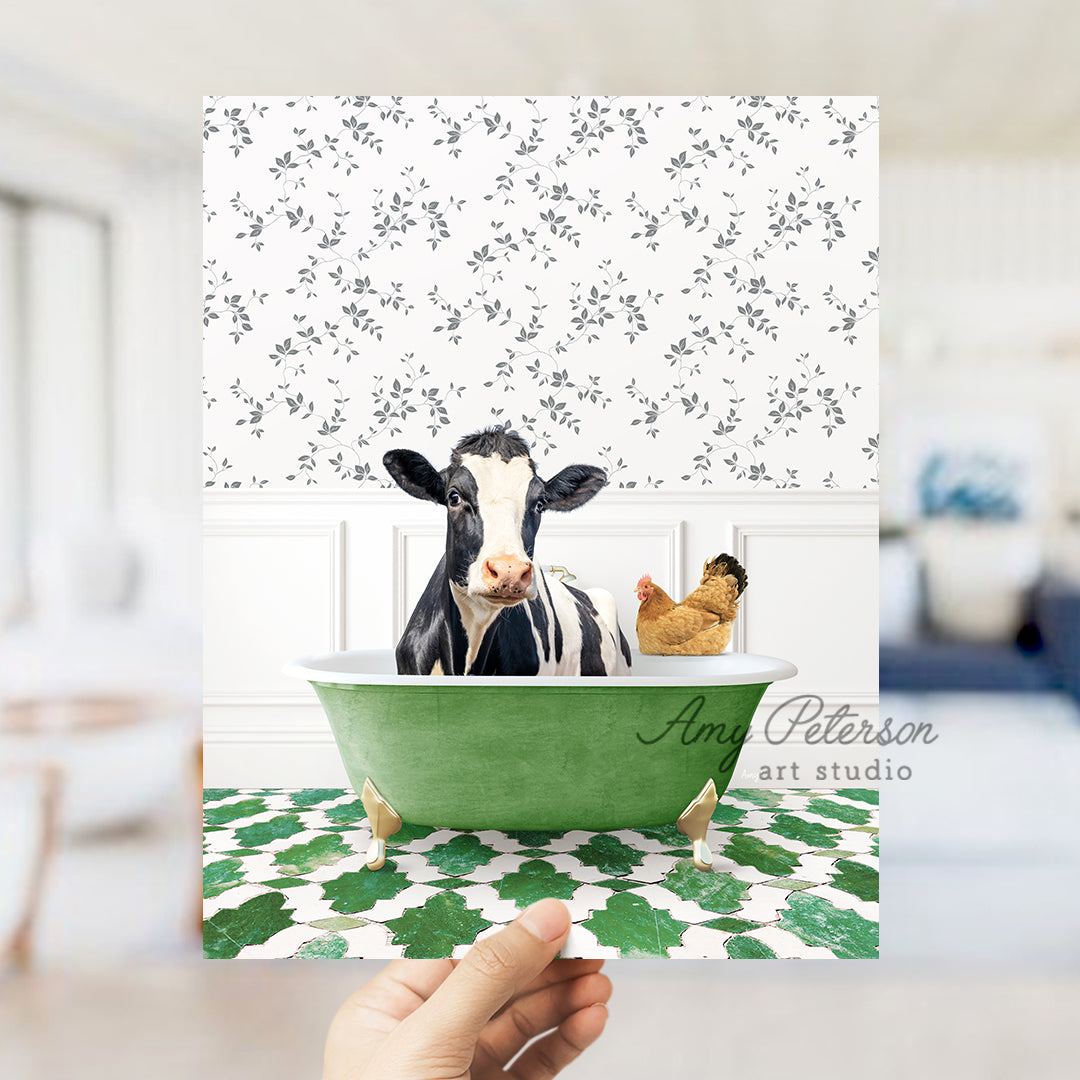 a hand holding up a card with a picture of a cow in a bathtub