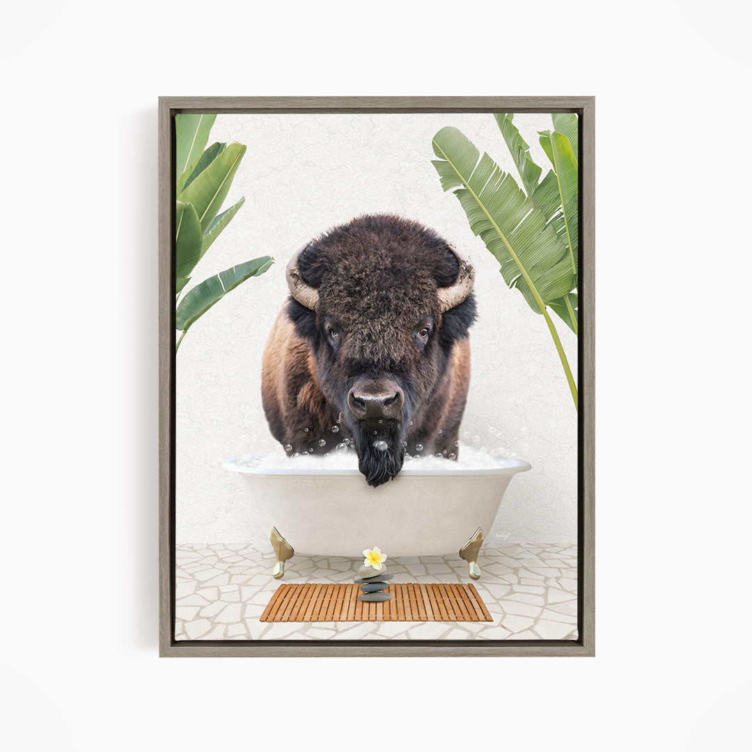 A buffalo is sitting in a bathtub filled with water, surrounded by tropical plants and a wooden mat on the floor.