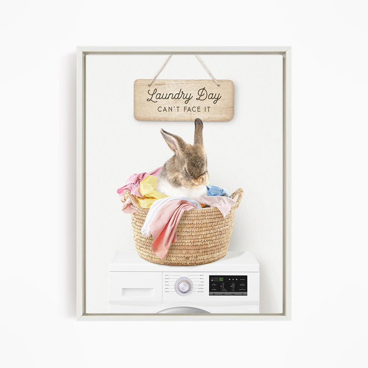 A cute rabbit sitting in a woven laundry basket, with a sign above that says "Laundry Day Can't Face It".