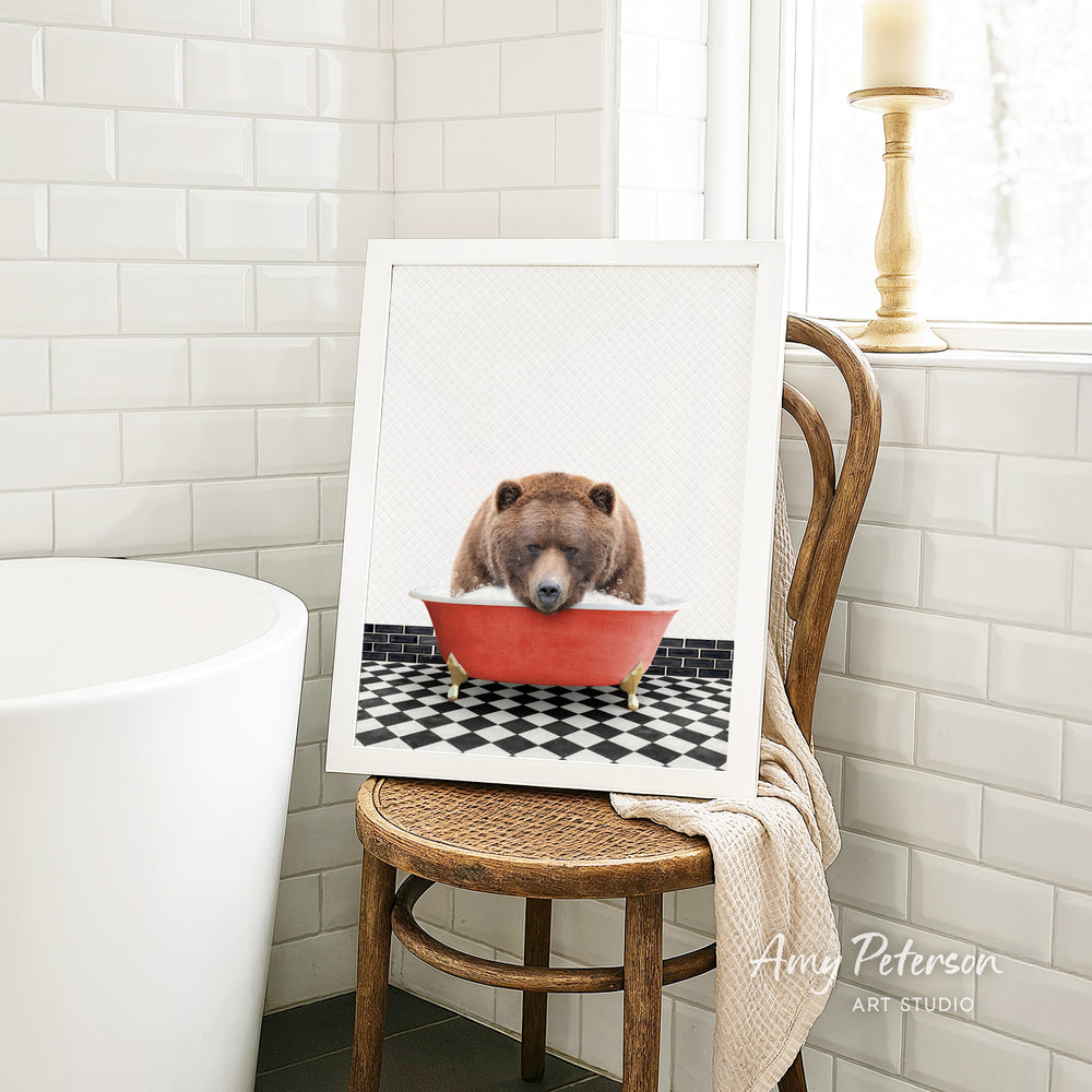 A framed image of a bear sitting in a red bathtub, with a black and white checkered floor in the background.