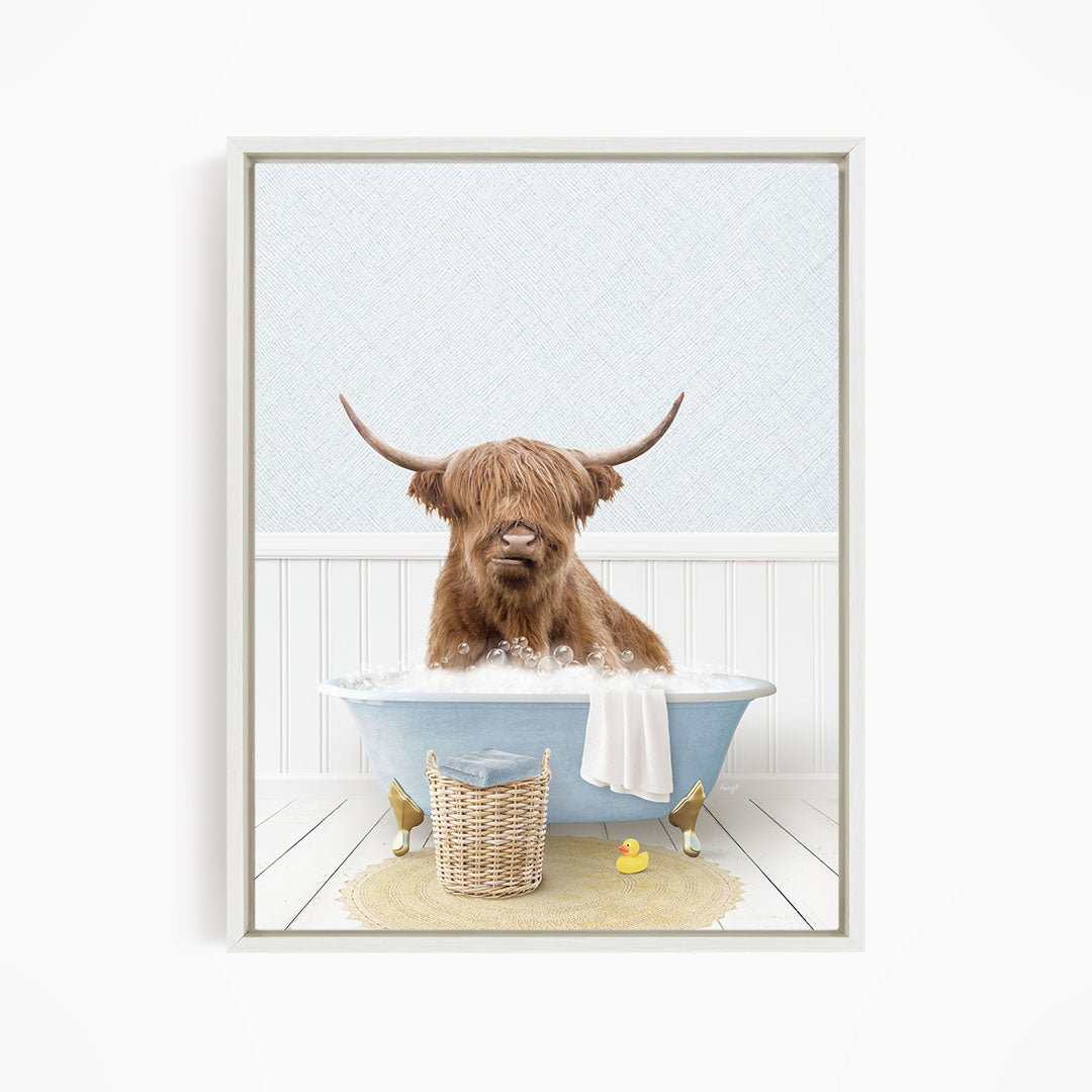 A brown cow with long horns is sitting in a blue bathtub filled with water, surrounded by a yellow rubber duck and a basket.