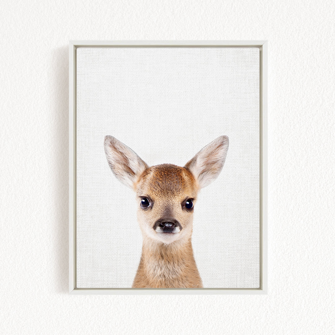 A framed print of a deer's head with large, alert eyes and a small nose, set against a plain white background.