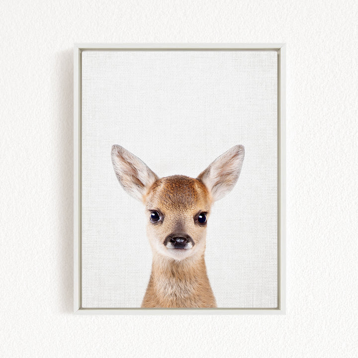 A framed print of a deer's head with large, alert eyes and a small nose, set against a plain white background.