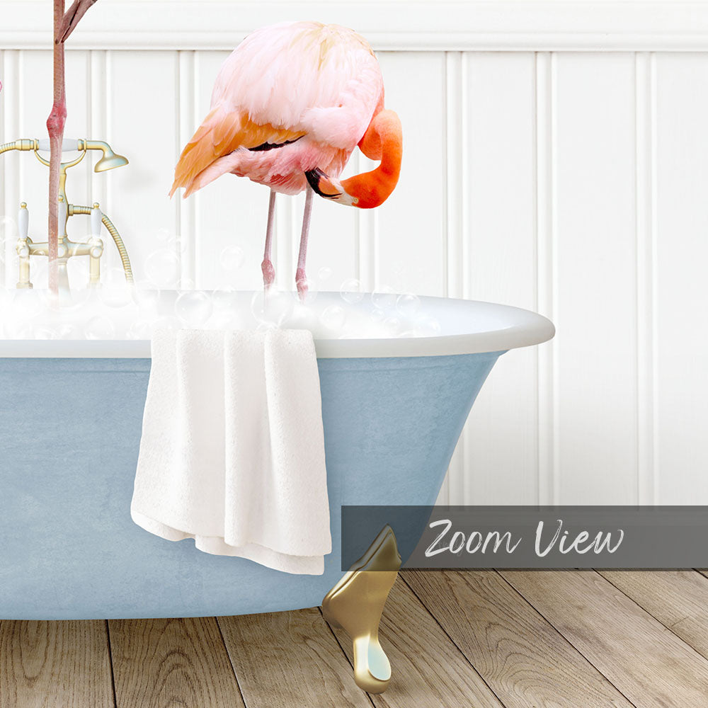 A pink flamingo stands in a blue bathtub filled with water, surrounded by a white towel and a gold bathtub leg.