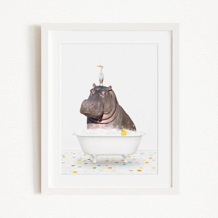 A framed image depicting a hippopotamus sitting in a bathtub, with a bird perched on its head.