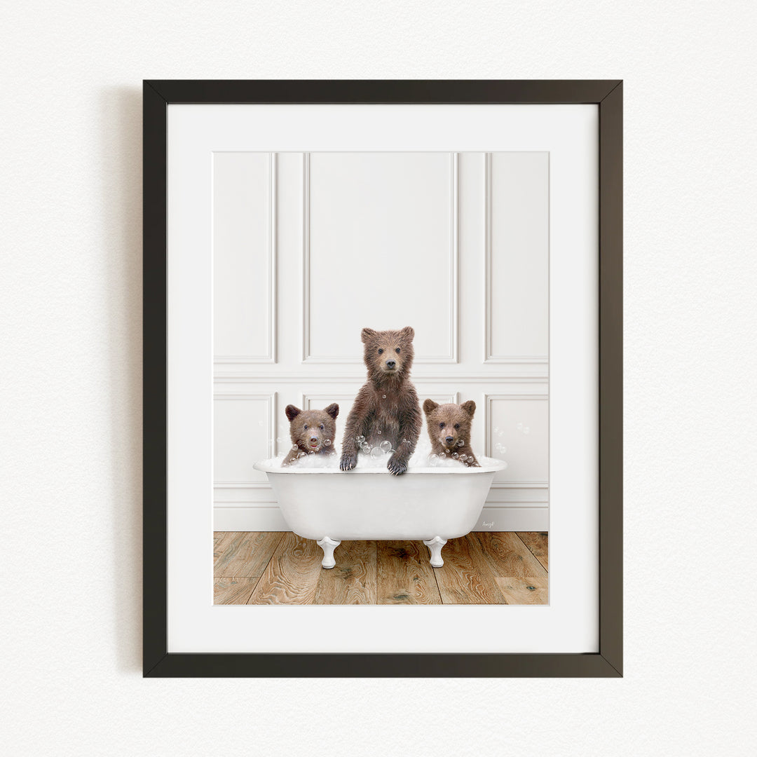 A framed image of three bears sitting in a white bathtub, with one bear sitting in the center and the other two bears sitting on either side.