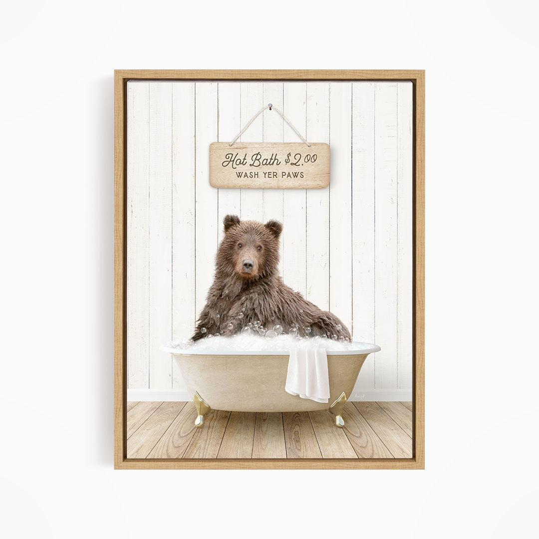 A brown bear sitting in a bathtub filled with water, with a sign above the bear that reads "Hot Bath $2.00 WASH YET Paws".