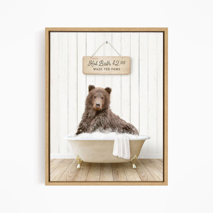 A brown bear sitting in a bathtub filled with water, with a sign above the bear that reads "Hot Bath $2.00 WASH YET Paws".