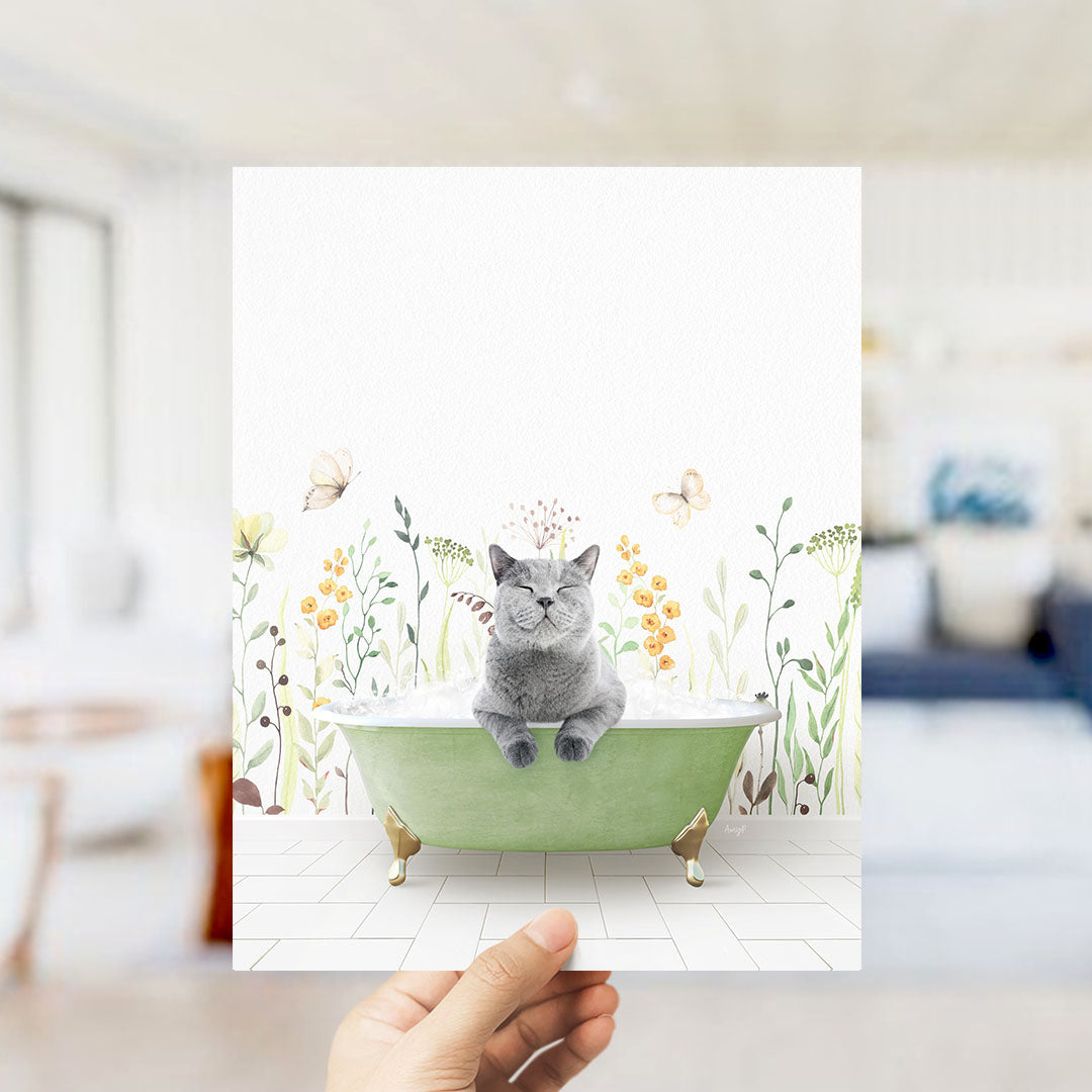 A gray cat sitting in a green bathtub filled with bubbles, surrounded by flowers and butterflies.