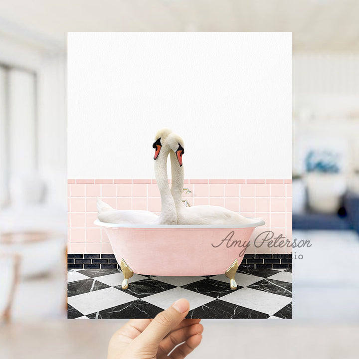 a person holding a card with a picture of two swans in a bathtub