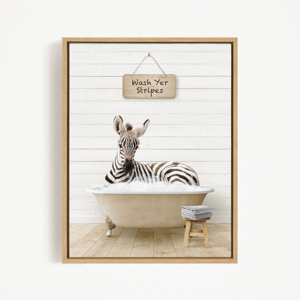A zebra is sitting in a bathtub, with a sign above it that says "Wash Yer Stripes".