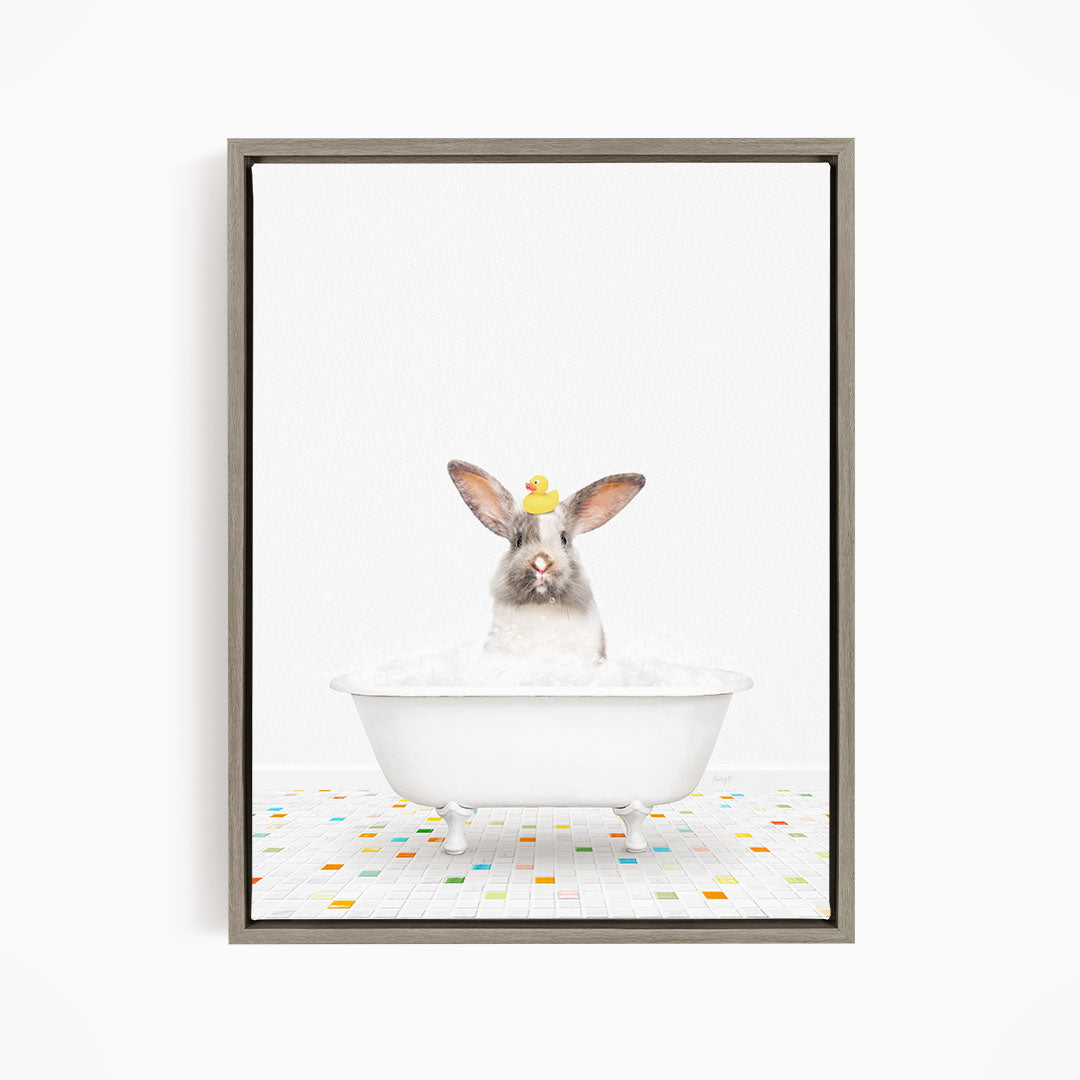 A white rabbit sitting in a white bathtub filled with bubbles, with a yellow rubber duck perched on its head.
