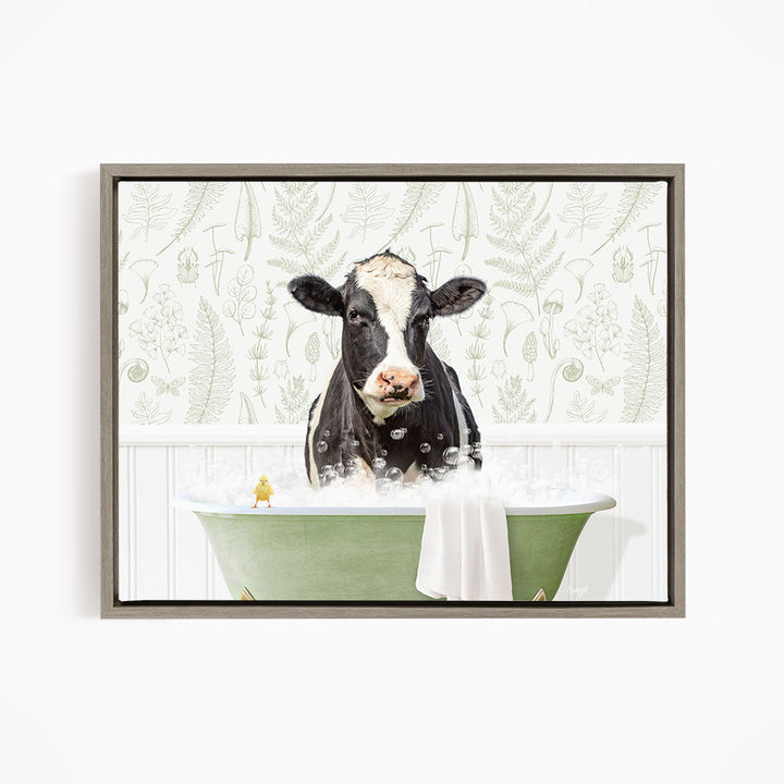 A black and white cow is sitting in a green bathtub filled with bubbles, with a yellow bird perched on the edge of the tub.