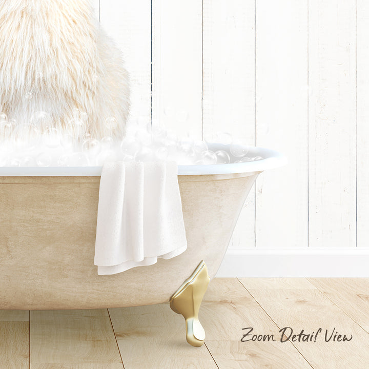 A fluffy white cat sitting in a bathtub filled with bubbles, with a towel draped over the side and a wooden floor visible in the background.