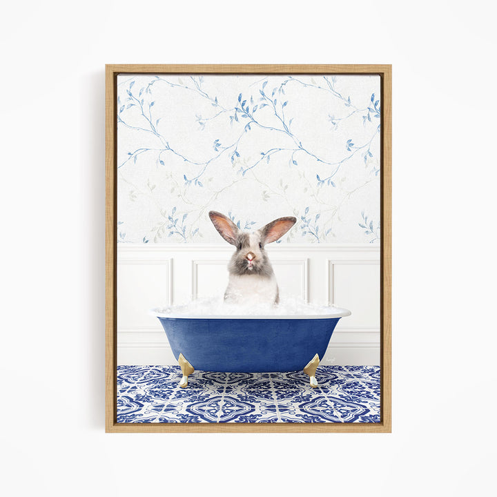 A white rabbit with brown ears is sitting in a blue bathtub filled with water, surrounded by a blue and white patterned rug.