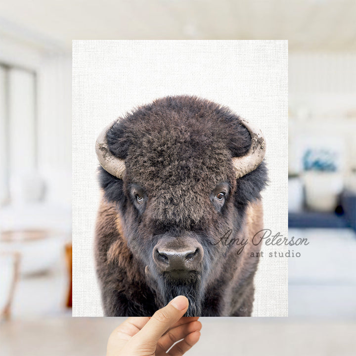 a person holding up a picture of a bison