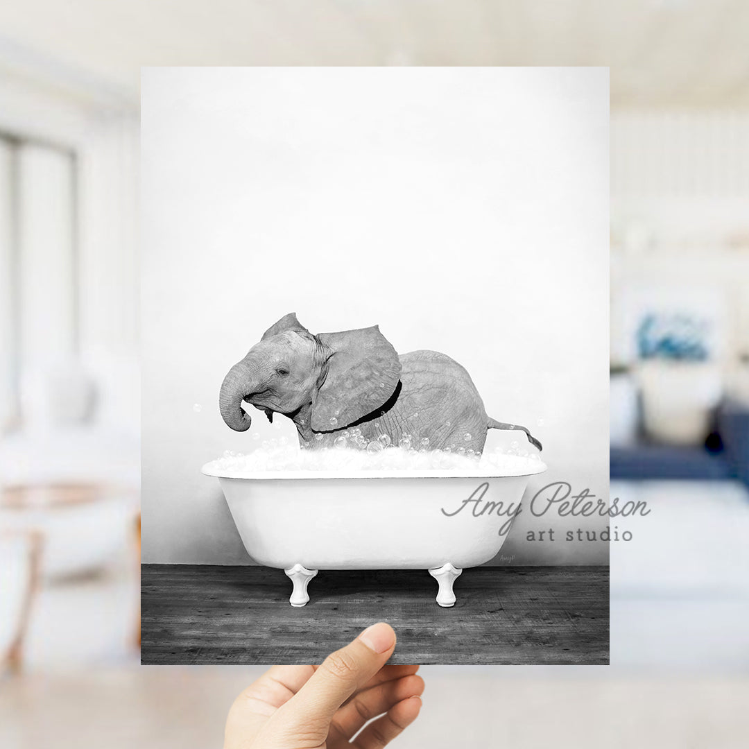 a hand holding up a card with an elephant in a bathtub