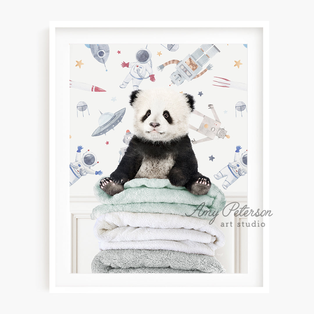 a panda bear sitting on top of a pile of towels