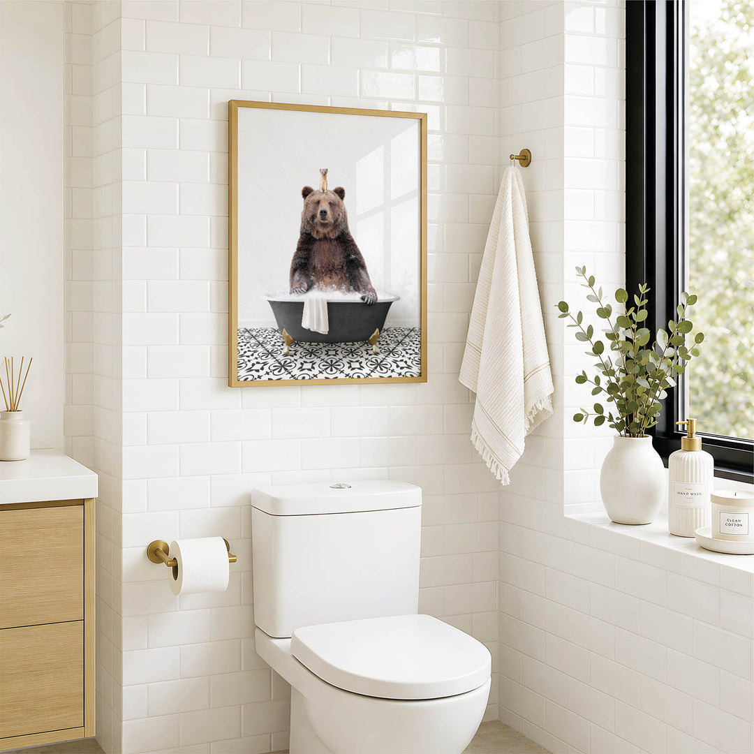 A bathroom with a white toilet, a framed image of a bear sitting in a bathtub, and a towel rack with a towel hanging on it.