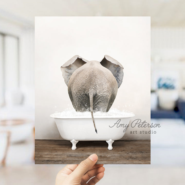 a person holding up a picture of an elephant in a bathtub