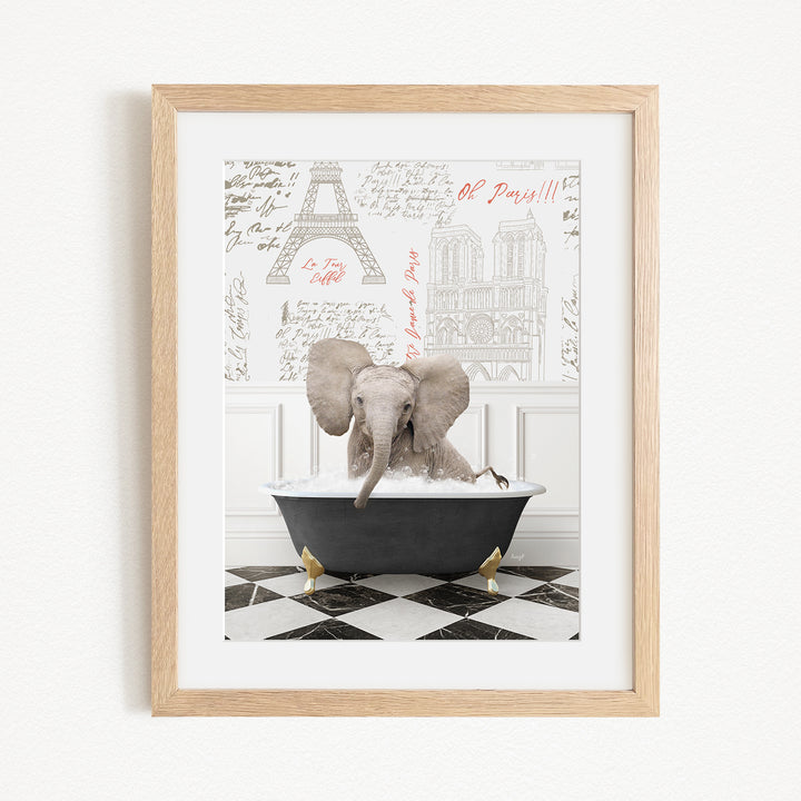 A framed image depicting an elephant sitting in a bathtub, with a Paris-themed background featuring the Eiffel Tower and other Parisian landmarks.