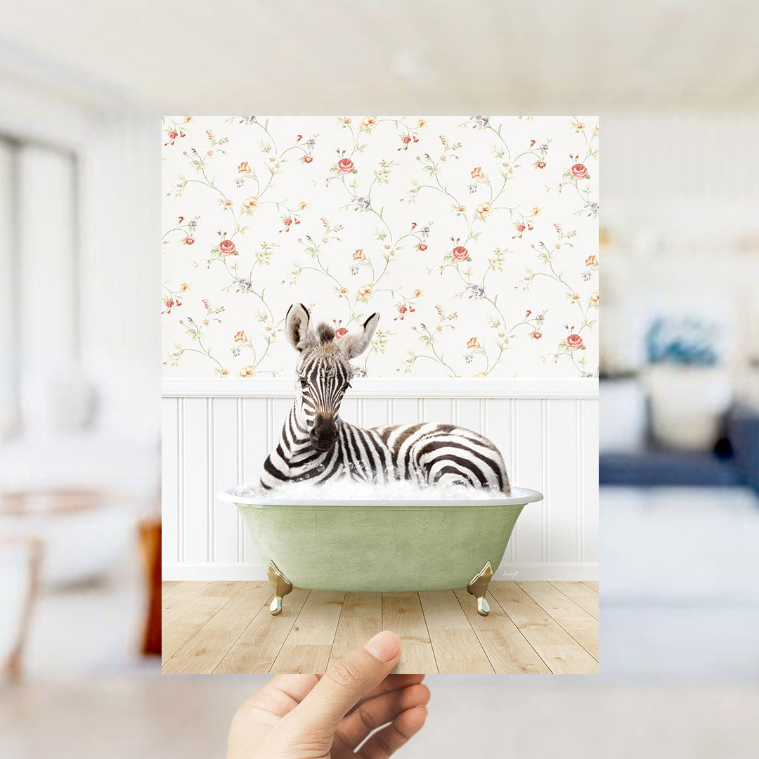 A zebra is sitting in a green bathtub, surrounded by a floral wallpaper.