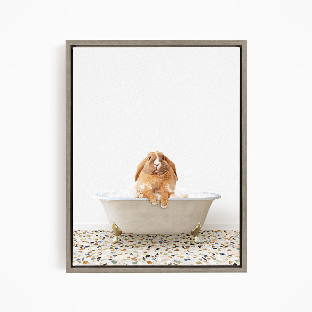 A brown rabbit sitting in a white bathtub filled with water, looking up at the camera.