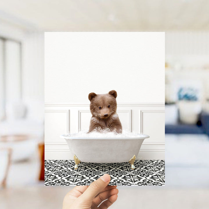 A brown bear sitting in a white bathtub filled with bubbles, surrounded by a black and white patterned floor.