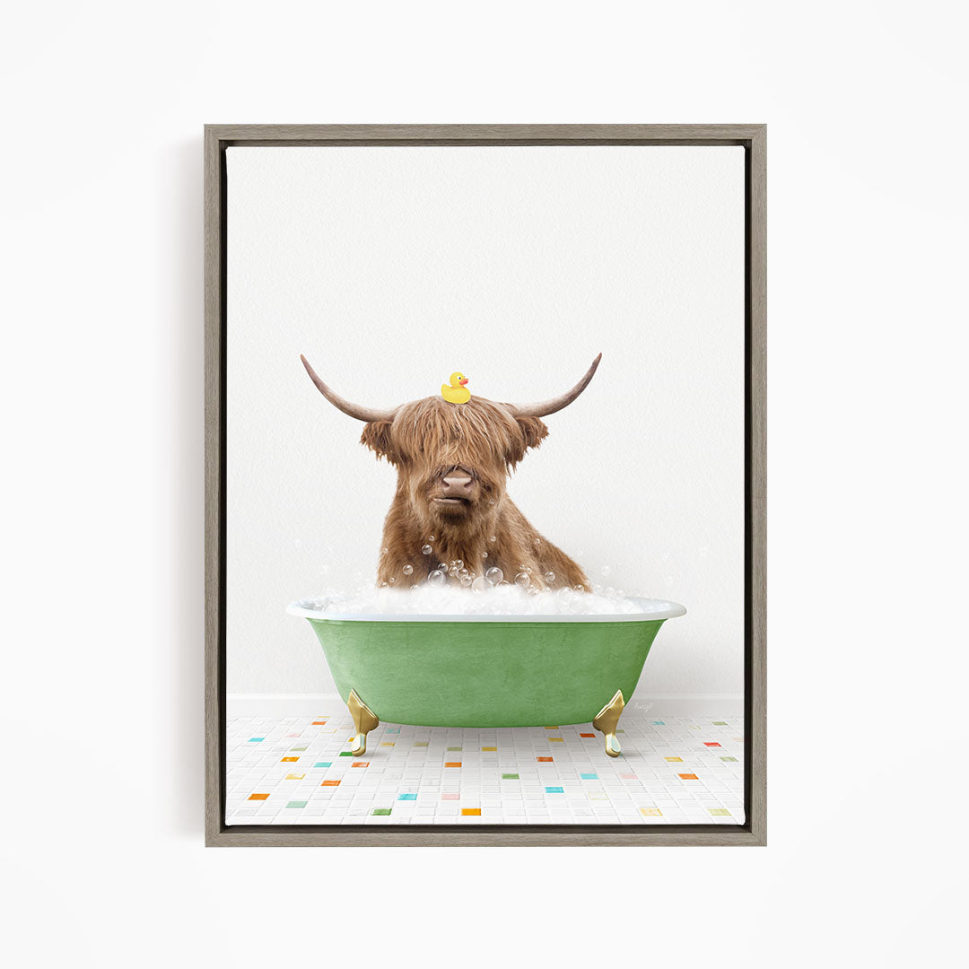A Highland cow with large horns is sitting in a green bathtub filled with bubbles, with a yellow rubber duck perched on its head.