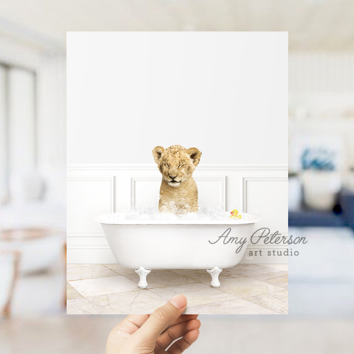 a hand holding up a card with a picture of a baby lion in a bath