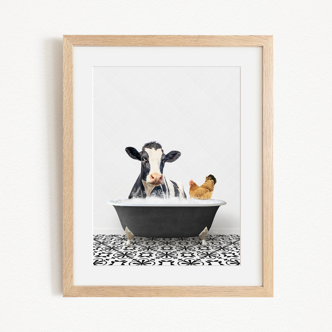 A framed image depicting a cow and a chicken relaxing in a bathtub together.