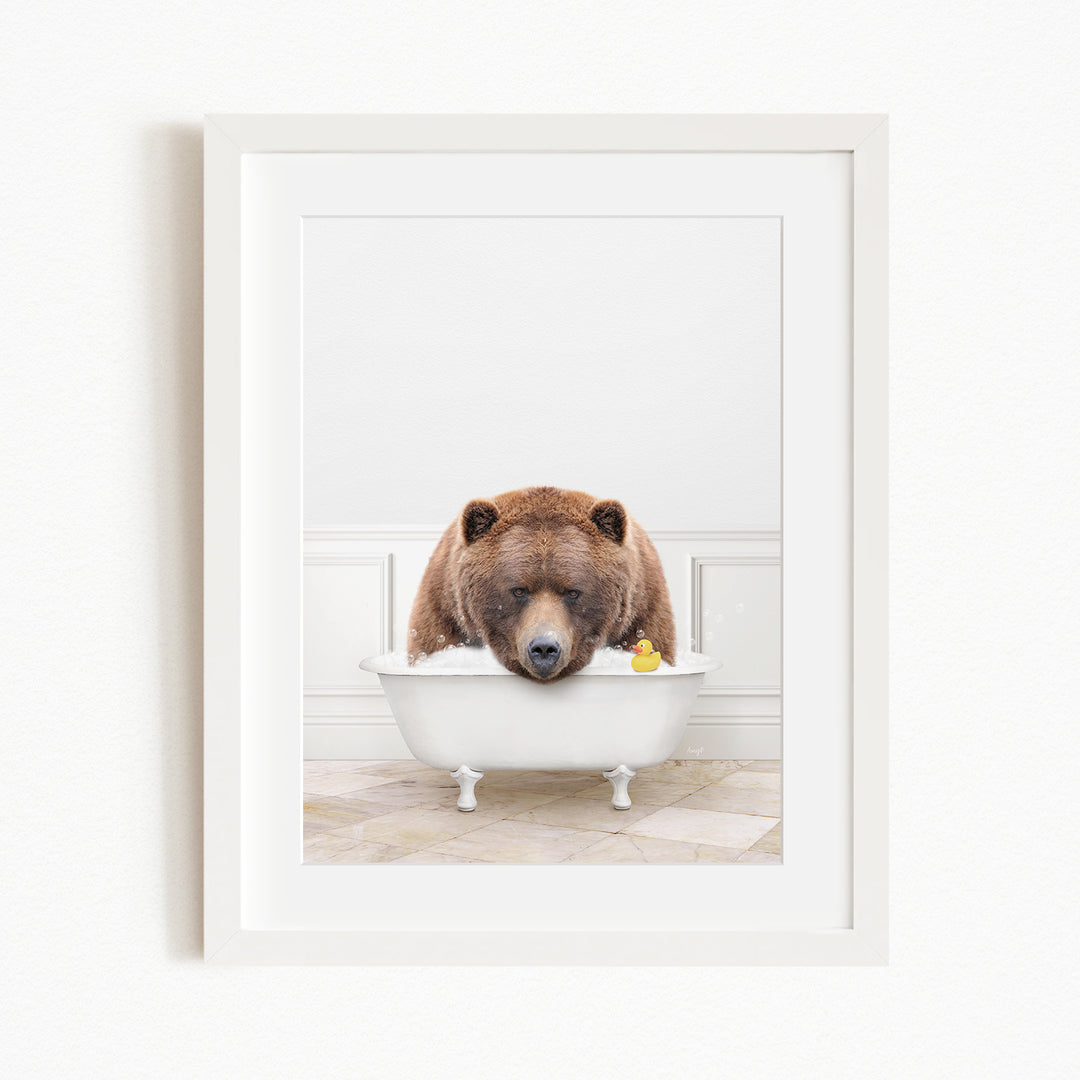 A brown bear is sitting in a white bathtub, surrounded by a yellow rubber duck.