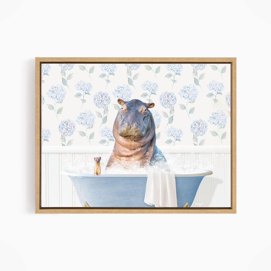 A framed image depicting a hippopotamus sitting in a bathtub, surrounded by a floral patterned wall and a small figurine.