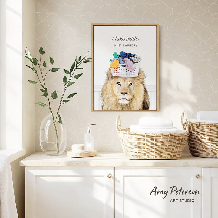 a framed poster of a lion wearing a laundry basket on its head, placed on a wall above a white cabinet with baskets.