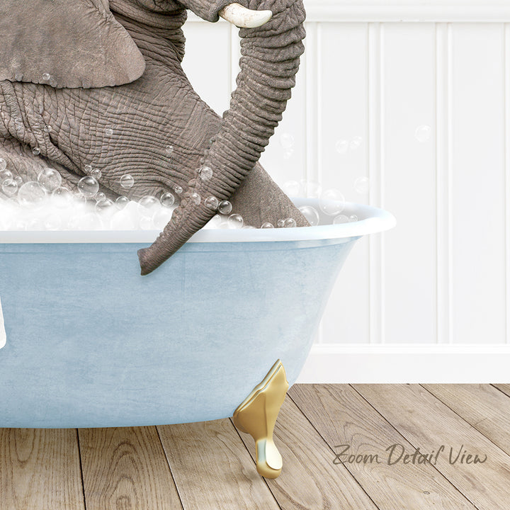 A large elephant is sitting in a blue bathtub filled with bubbles, with its trunk submerged in the water.
