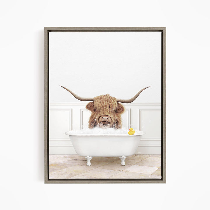 A long-haired cow with large horns is sitting in a white bathtub, surrounded by a yellow rubber duck.
