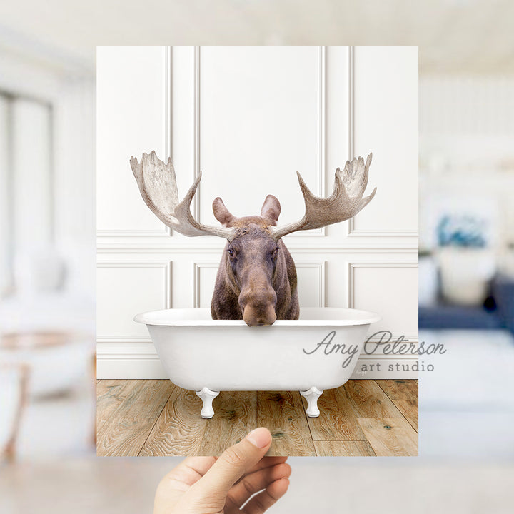 a hand holding up a card with a picture of a moose in a bathtub