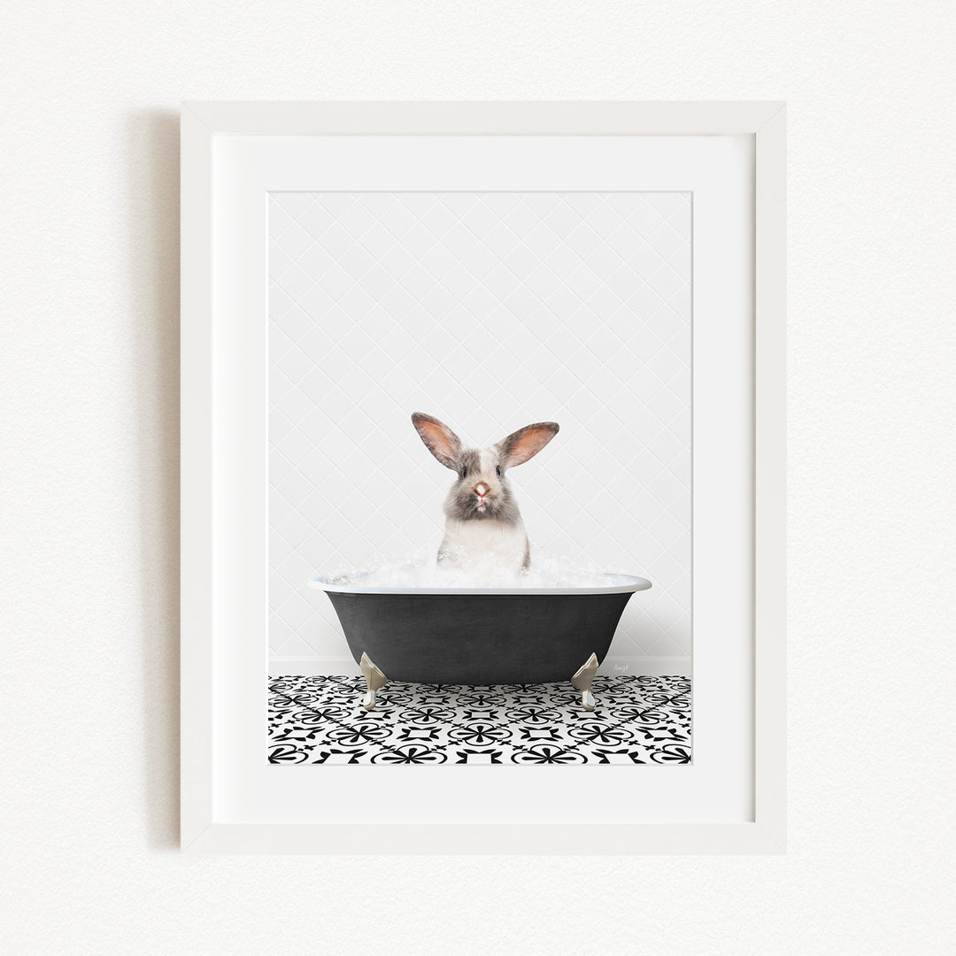 A white rabbit sitting in a black bathtub filled with water, with a black and white patterned tile floor beneath it.