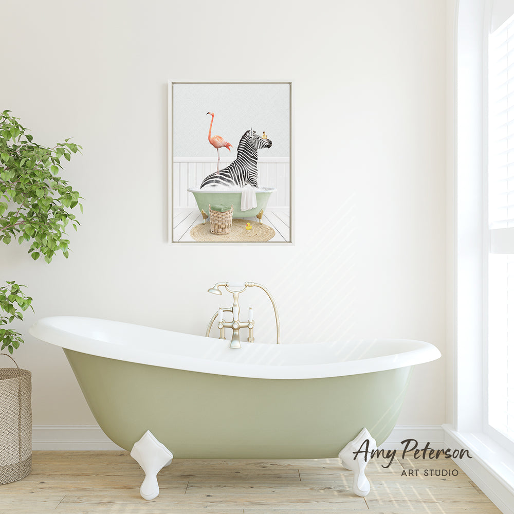 A green clawfoot bathtub with a framed illustration of a zebra and a flamingo in a bathtub on the wall above it.