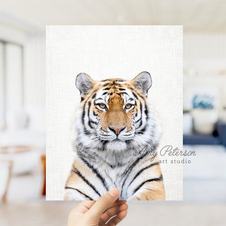 a hand holding up a picture of a tiger