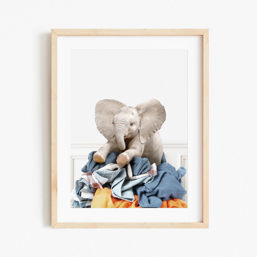 an elephant sitting on top of a pile of clothes