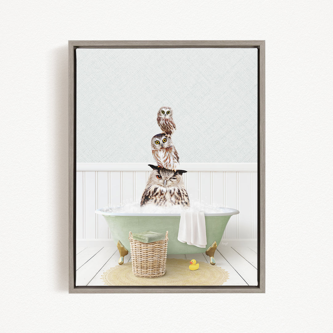 A framed image depicting three owls sitting in a bathtub, with one owl sitting on top of the other two.