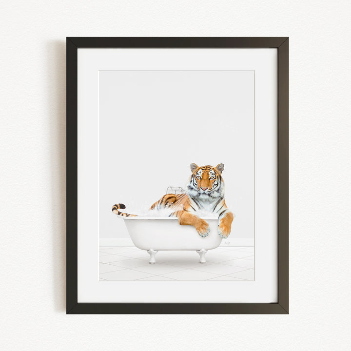 A tiger is sitting in a white bathtub, appearing relaxed and enjoying the bath.