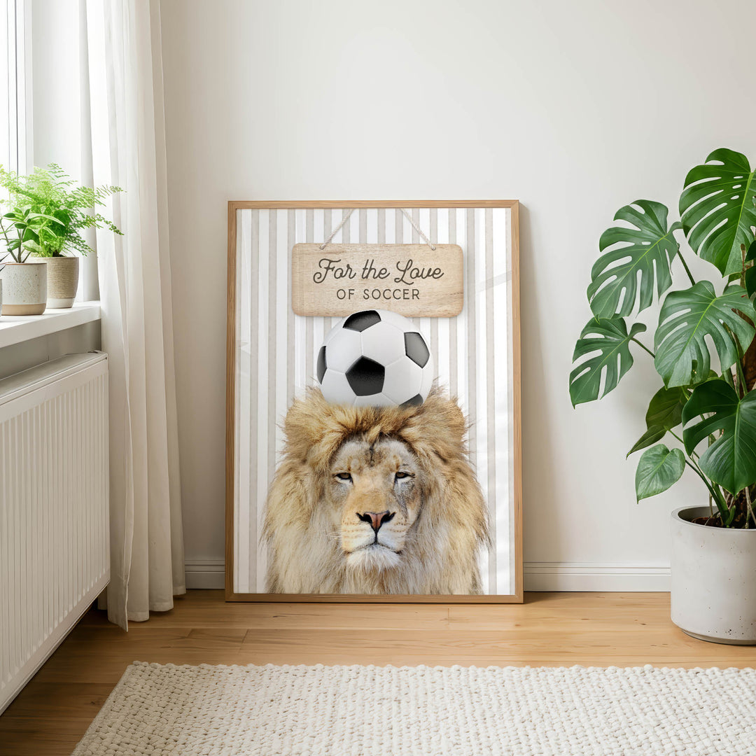 a framed poster of a lion with a soccer ball on its head, placed on a wall in a room with a rug and potted plants.