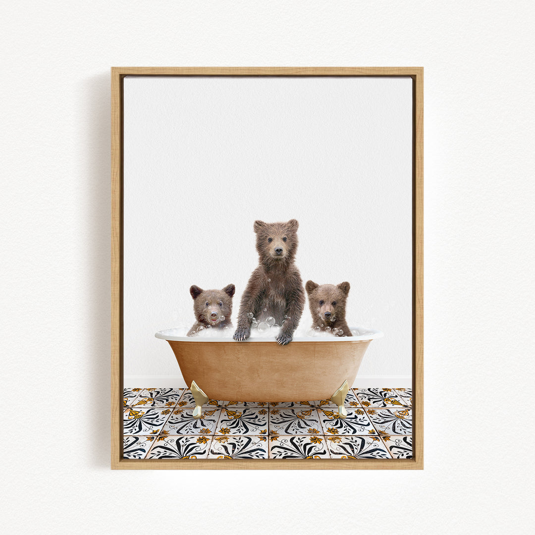 A framed image depicting three brown bears sitting in a bathtub filled with water, with a patterned tile floor beneath.